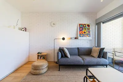a living room with a blue couch and a lamp at S1405 - practical and modern - AC, balcony and parking in Porto