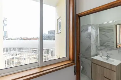 a bathroom with a window and a sink with a view at Lolla's City House 2 in Porto