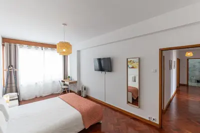 a bedroom with a bed and a tv on a wall at Lolla's City House 2 in Porto