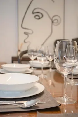 a table with plates and wine glasses on it at Liiiving in Gaia - Cooper Residence Apartment II in Vila Nova de Gaia