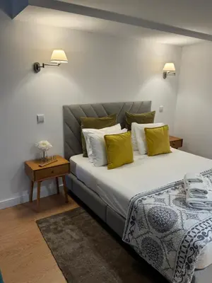 a bedroom with a large bed with yellow pillows at luxury stay Romantic Douro River & Sunset views in Porto