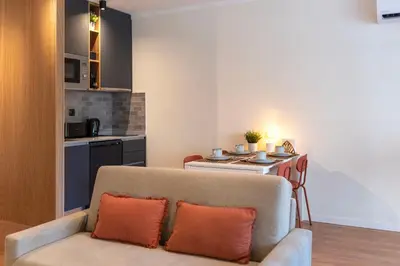 a living room with a couch and a kitchen at DOISPONTOZERO Bragas in Porto