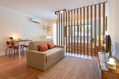 a living room with a couch and a dining room at DOISPONTOZERO Bragas in Porto