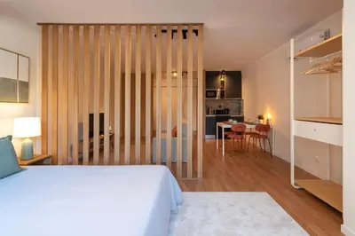 a bedroom with a white bed and a dining room at DOISPONTOZERO Bragas in Porto