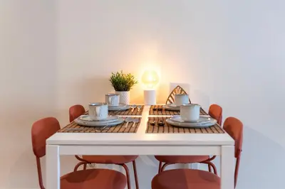 a dining room table with chairs and a white table with teaisers at DOISPONTOZERO Bragas in Porto
