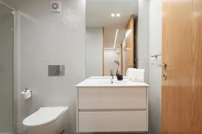a bathroom with a white sink and a toilet at Luxury stay Premium Douro River & Sunset views in Porto