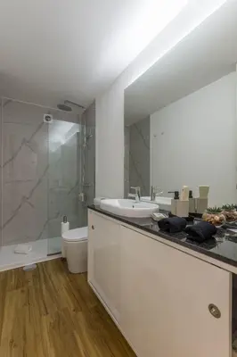 a bathroom with a sink and a toilet and a mirror at OPO Vale Formoso III Balcony&BBQ in Porto