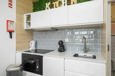 a small kitchen with a sink and a microwave at Constituição Flat by Amber Star Rent in Porto