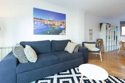 a living room with a blue couch and a table at Host Wise - Deluxe Modern Flat w Balcony in Porto