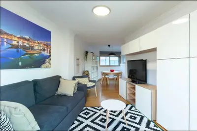 a living room with a blue couch and a kitchen at Host Wise - Deluxe Modern Flat w Balcony in Porto