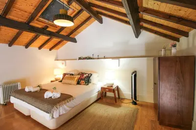 a bedroom with a large bed in a room with wooden ceilings at Mouzinho Mezzanine in Porto