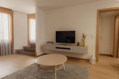 a living room with a table and a tv at Coruja’s House AL OPO in Porto