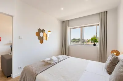 a white bedroom with a bed and a window at Lusi'Apartment - Douro River so close by Guest SPA in Porto