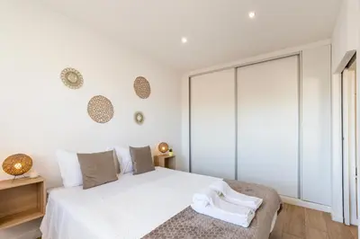 a white bedroom with a bed and a window at Lusi'Apartment - Douro River so close by Guest SPA in Porto