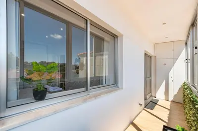 a balcony with a large window with a plant at Lusi'Apartment - Douro River so close by Guest SPA in Porto