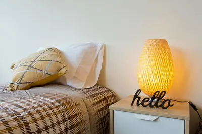 a bedroom with a bed and a yellow lamp on a nightstand at Host Wise - Spacious Trendy Flat w Netflix - Central Location in Porto