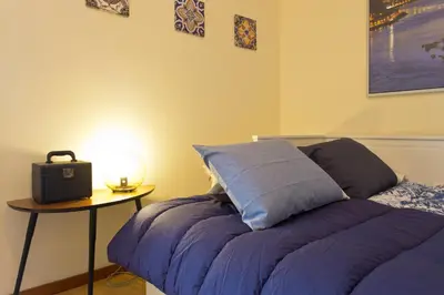 a bedroom with a bed and a table with a lamp at Host Wise - Spacious Trendy Flat w Netflix - Central Location in Porto