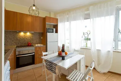 a kitchen with a white table and chairs in a room at Host Wise - Spacious Trendy Flat w Netflix - Central Location in Porto