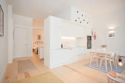 a white kitchen with a table and a dining room at Liiiving in Porto - Haven Pool Apartment in Porto