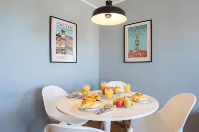 a table with plates of food and glasses of orange juice at Host Wise - Fantastic Peaceful Flat in Gaia in Vila Nova de Gaia