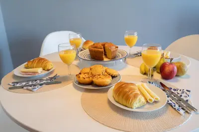 a table with plates of food and glasses of orange juice at Host Wise - Fantastic Peaceful Flat in Gaia in Vila Nova de Gaia