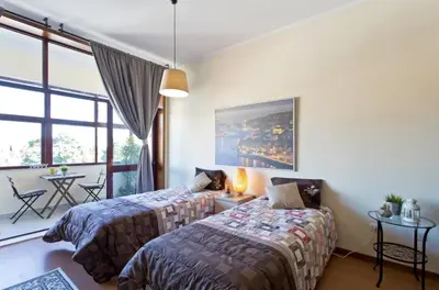 a bedroom with two beds and a table at Host Wise - Cozy Sunny Flats - Ace Location in Porto