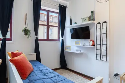 a living room with a blue couch and a tv at Host Wise - Cozy Sunny Flats - Ace Location in Porto