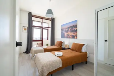 a bedroom with two beds and a window at Host Wise - Cozy Sunny Flats - Ace Location in Porto