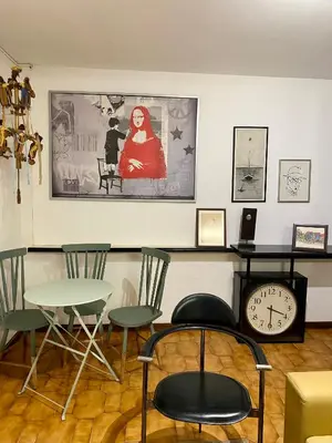 a room with a table and chairs and a clock at Jardim do Morro Places in Vila Nova de Gaia