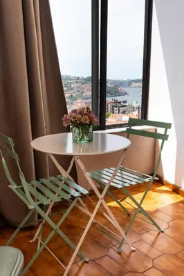 a table and two chairs in front of a window at Jardim do Morro Places in Vila Nova de Gaia
