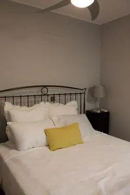 a white bed with a yellow pillow on it at Jardim do Morro Places in Vila Nova de Gaia