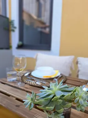 a wooden table with a plate and a plant on it at Boavista Luxury Villas in Porto