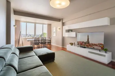 a living room with a couch and a flat screen tv at Carolina Roomy & Modern Apartment in Porto