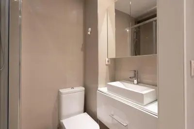 a white bathroom with a toilet and a sink at Carolina Roomy & Modern Apartment in Porto