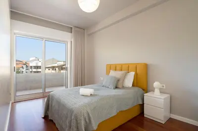 a bedroom with a bed and a large window at Carolina Roomy & Modern Apartment in Porto