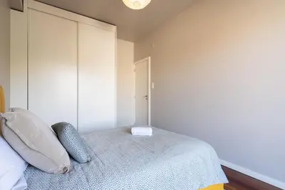 a bedroom with a bed and a white cabinet at Carolina Roomy & Modern Apartment in Porto