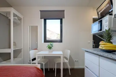 a small room with a table and a kitchen at Host Wise - Impressive Restful Houses in Porto