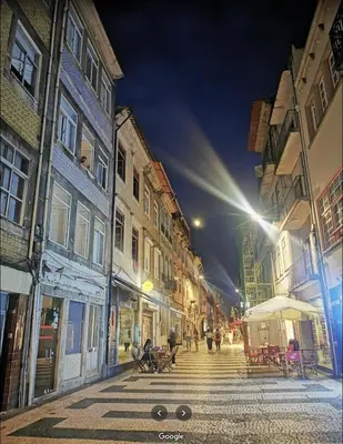 a city street at night with people walking down the street at BREINER 54 in Porto
