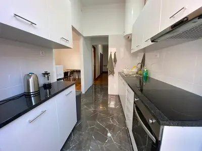 a kitchen with white cabinets and black counter tops at BREINER 54 in Porto