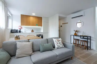 a living room with a couch and a kitchen at Nomads Lux - 1BDR Charming Top Floor Porto in Porto