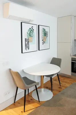 a white kitchen with a washing machine and a table at Trindade Apartments by PHC in Porto