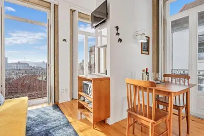 a dining room with a table and a window at Host Wise - Lovely Shinny Flats with Balcony - Clerigos in Porto