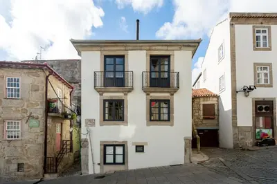 a white building with a balcony on a street at Miragaia Apartments by DA'HOME in Porto