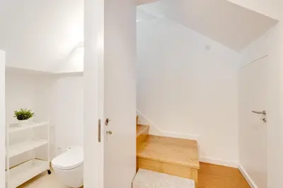 a white bathroom with a toilet and a sink at Miragaia Apartments by DA'HOME in Porto