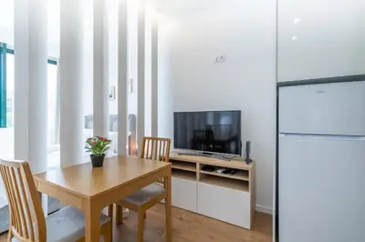 a dining room with a table and a television at Window to Porto by Amber Star Rent in Porto