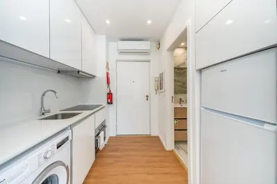 a white kitchen with a sink and a dishwasher at Window to Porto by Amber Star Rent in Porto