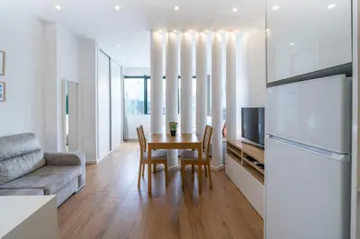 a kitchen and living room with a table and a refrigerator at Window to Porto by Amber Star Rent in Porto
