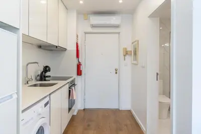 a kitchen with white cabinets and a sink and a door at Window to Porto by Amber Star Rent in Porto