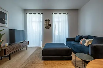 a living room with a blue couch and a tv at Nomad's Lux - Almada Apartments Porto in Porto