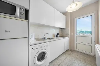 a white kitchen with a sink and a washing machine at New Apartments Luiz I Bridge by Amber Star Rent in Vila Nova de Gaia